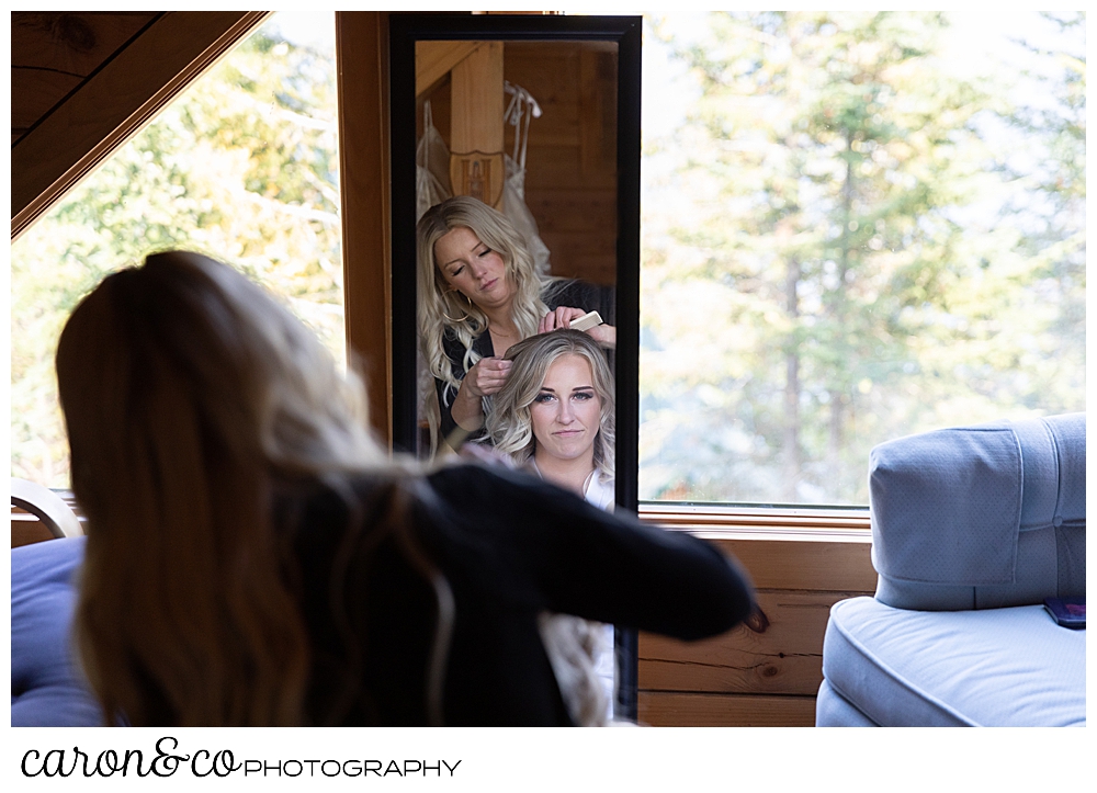 a reflection in a mirror of a bride having her hair done