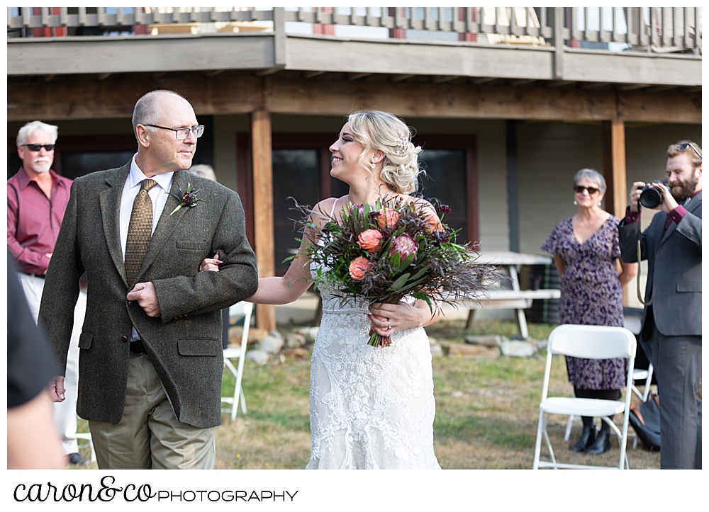 a bride and her father on their approach toward the groom at a Rangley Maine wedding ceremony