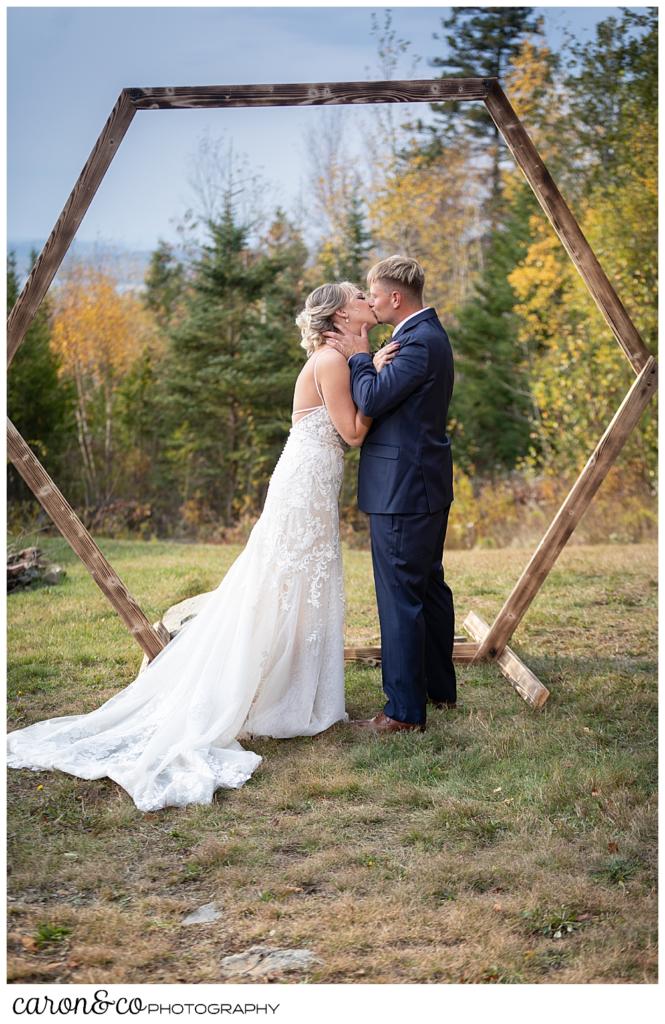 a bride and groom share their first kiss at their Rangeley Maine wedding ceremony