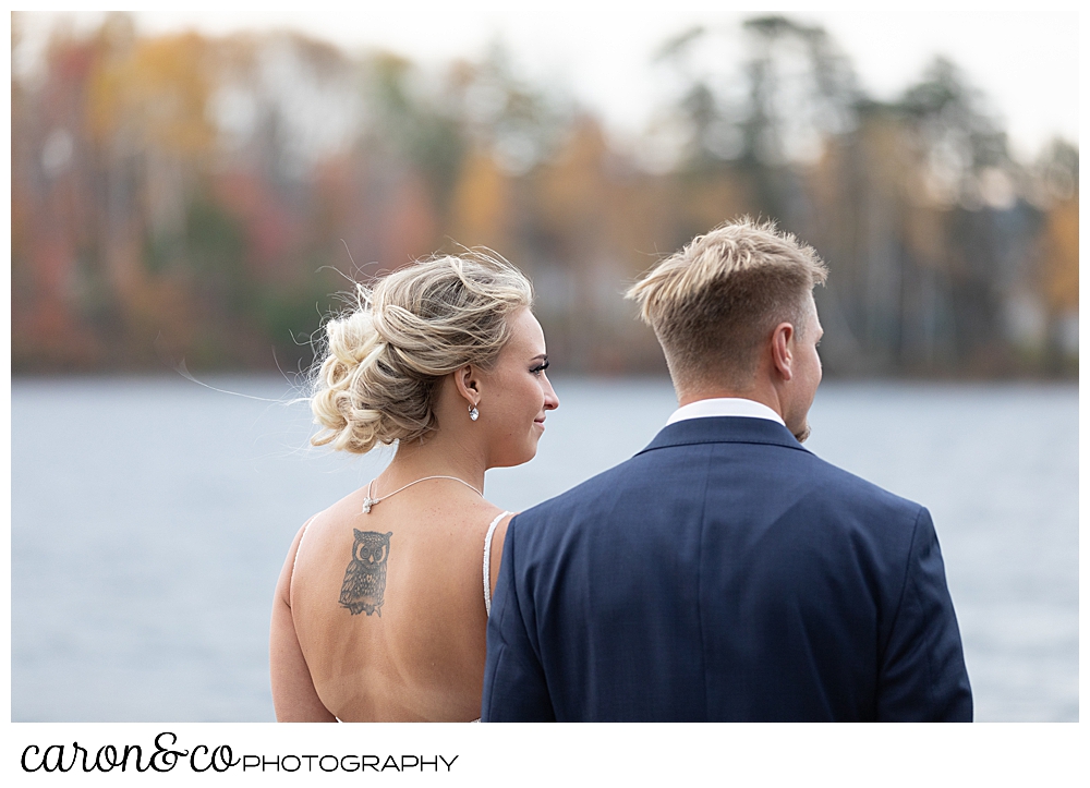 a bride and groom looking out over Rangeley Lake, Rangley Maine wedding