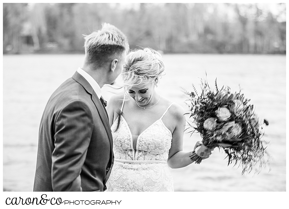 black and white photo of a bride and groom standing on the shores of Rangeley Lake, during a Rangeley Maine wedding