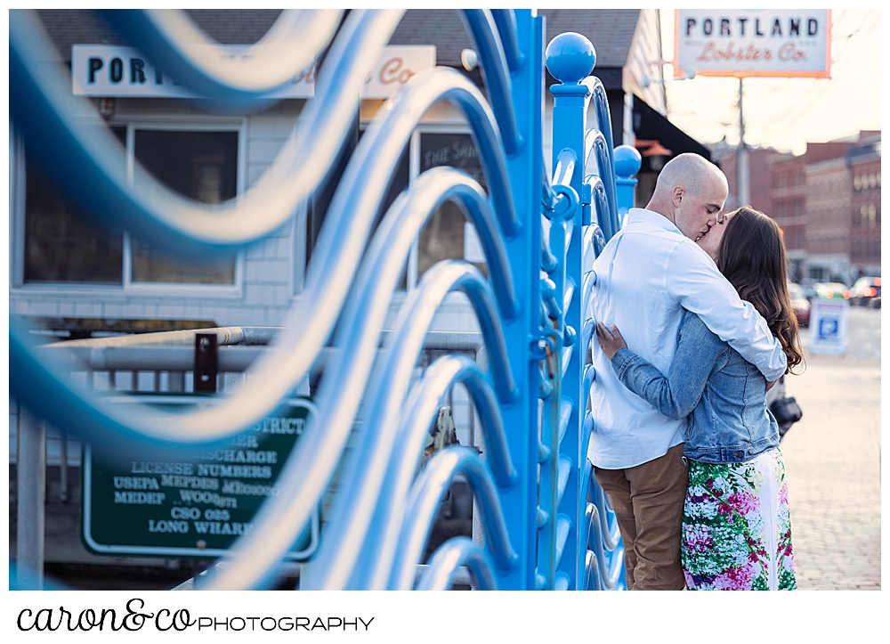 man and woman kissing by the wave wall during a Portland Maine spring engagement session