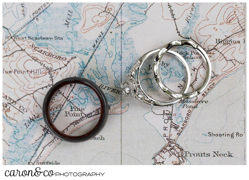 wedding bands and engagement ring on a background of a Maine map, the man's ring is encircling Pine Point Maine wedding