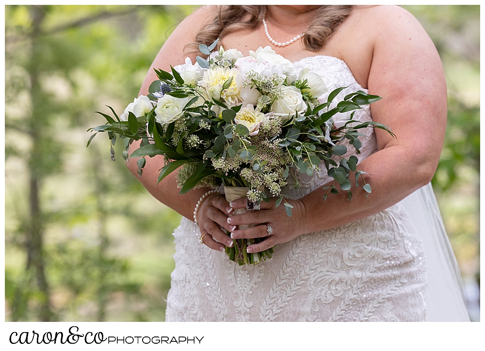 bride holding a beautiful bouquet of white, blush, yellow, and green