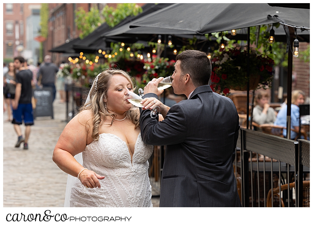 a bride and groom toast each other with champagne, on Wharf Street, Old Port, Portland, Maine