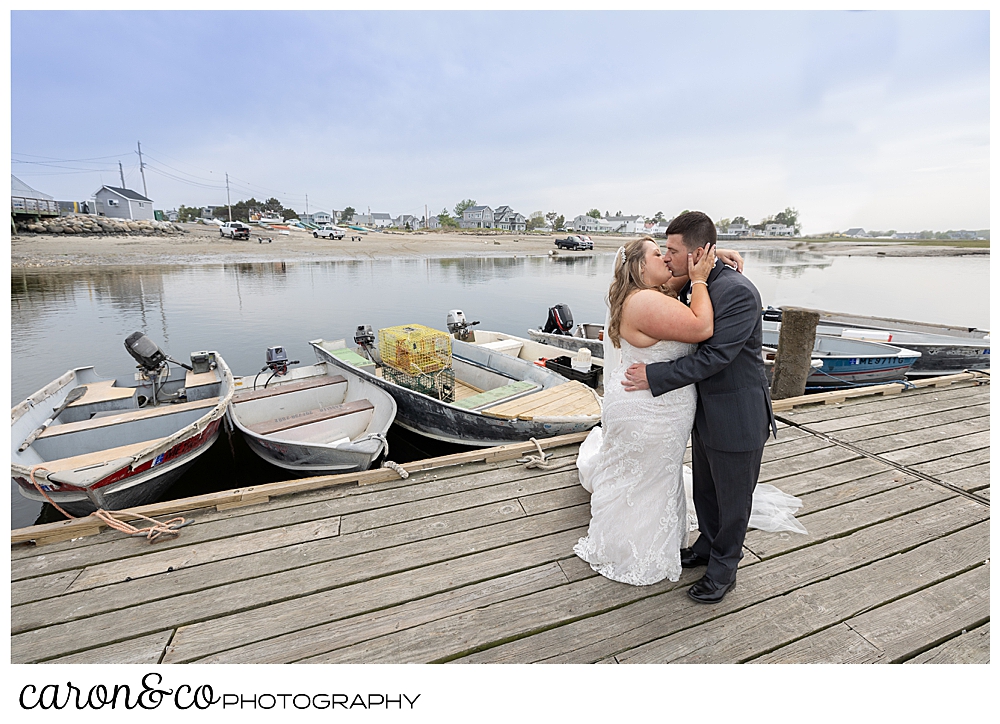 a bride and groom kissing on a fishing dock, at Pine Point, Scarborough, Maine