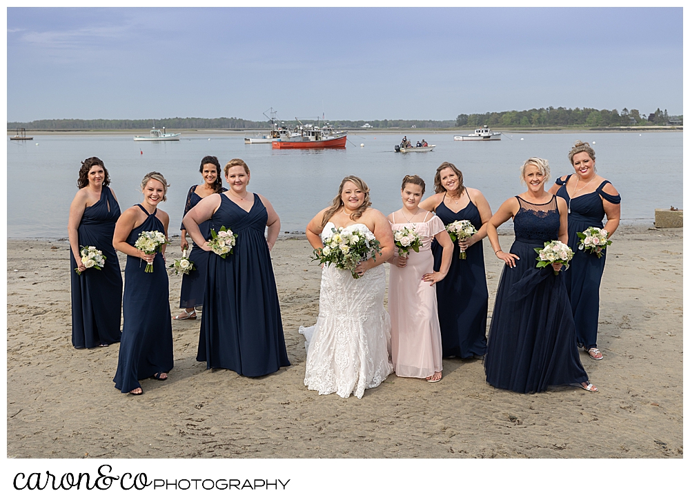 a bride in white, with her bridesmaids in blue, standing on the beach at Pine Point, Scarborough, Maine weddings