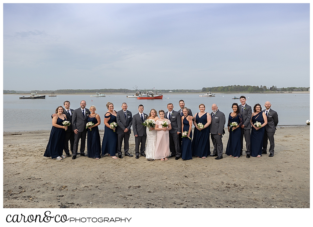 a bride and groom stand together with their bridal on the beach at Pine Point Fisherman's Coop, Pine Point, Scarborough, Maine