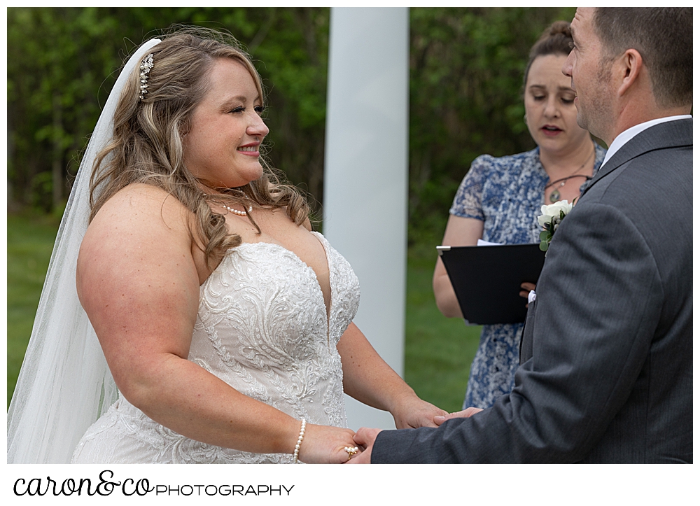 a beautiful bride smiles at her groom during their Pine Point Maine wedding ceremony