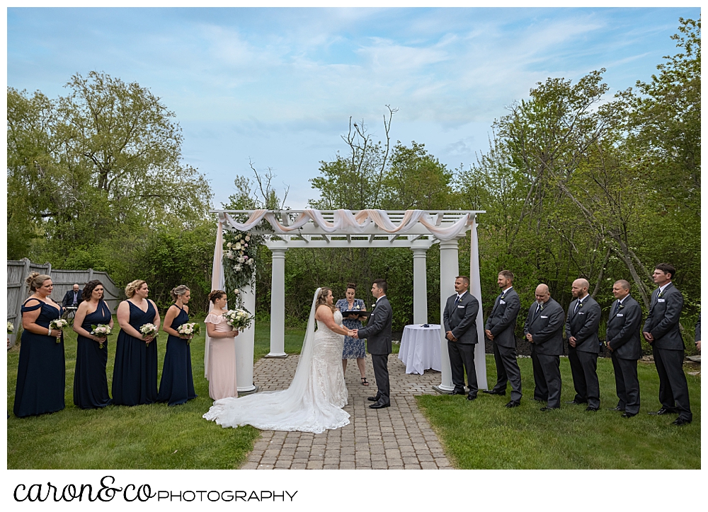 the pergola at the Landing at Pine Point, Scarborough, Maine, with a bride, groom, officiant, and wedding party