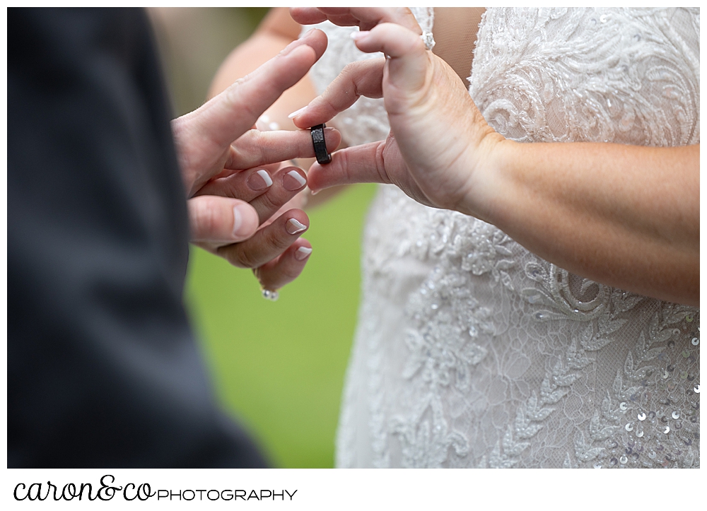 a bride putting a wedding band on the finger of her groom, at their Pine Point Maine wedding