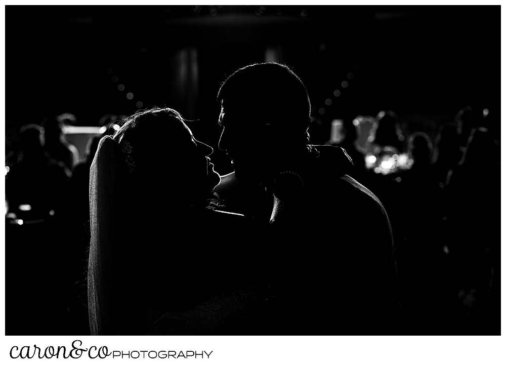 a black and white silhouette of a bride and groom during their first dance