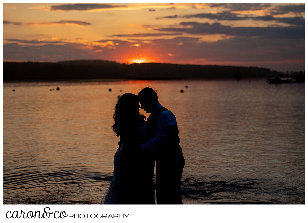 a silhouette of a bride and groom during a gorgeous sunset at their Pine Point Maine wedding