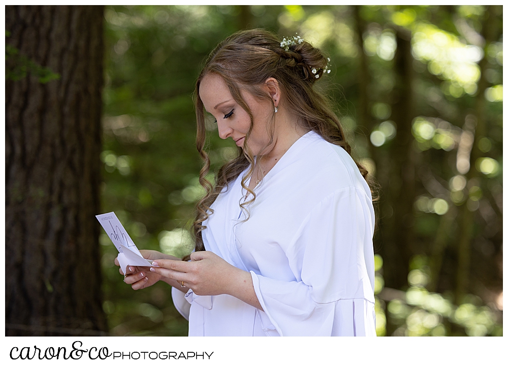 a bride in white robe, reads a letter from her groom