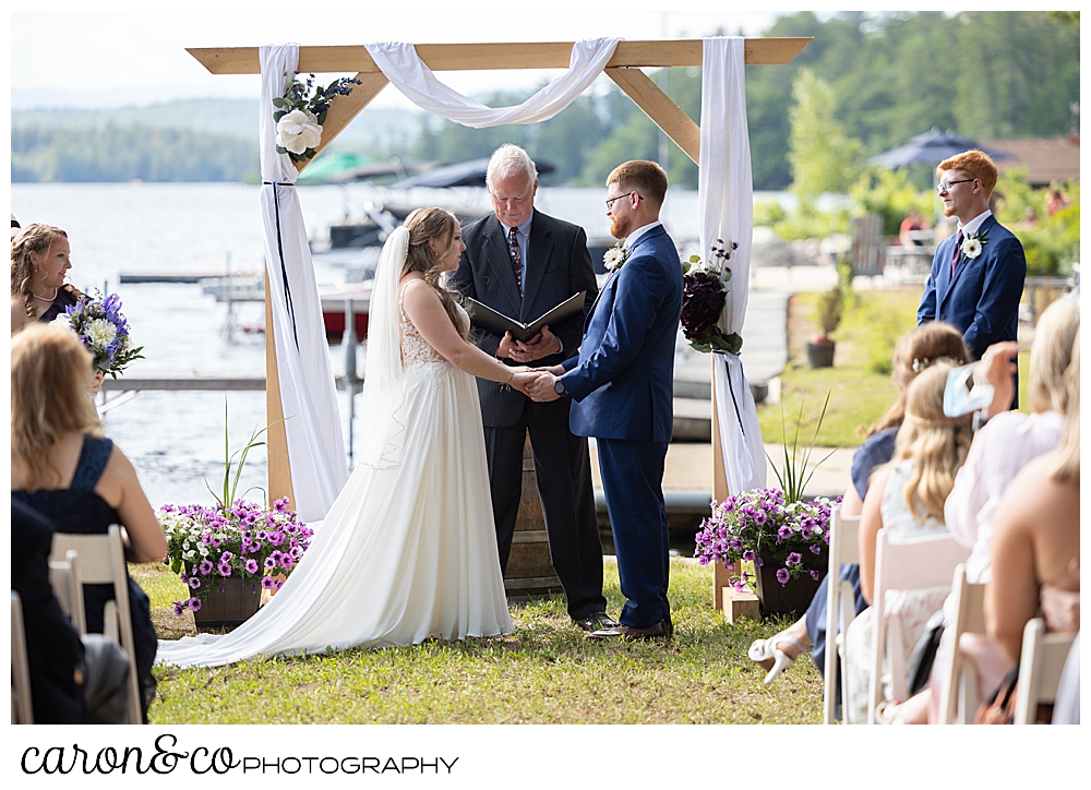 bride and groom standing before an officiant at their highland lake maine wedding ceremony