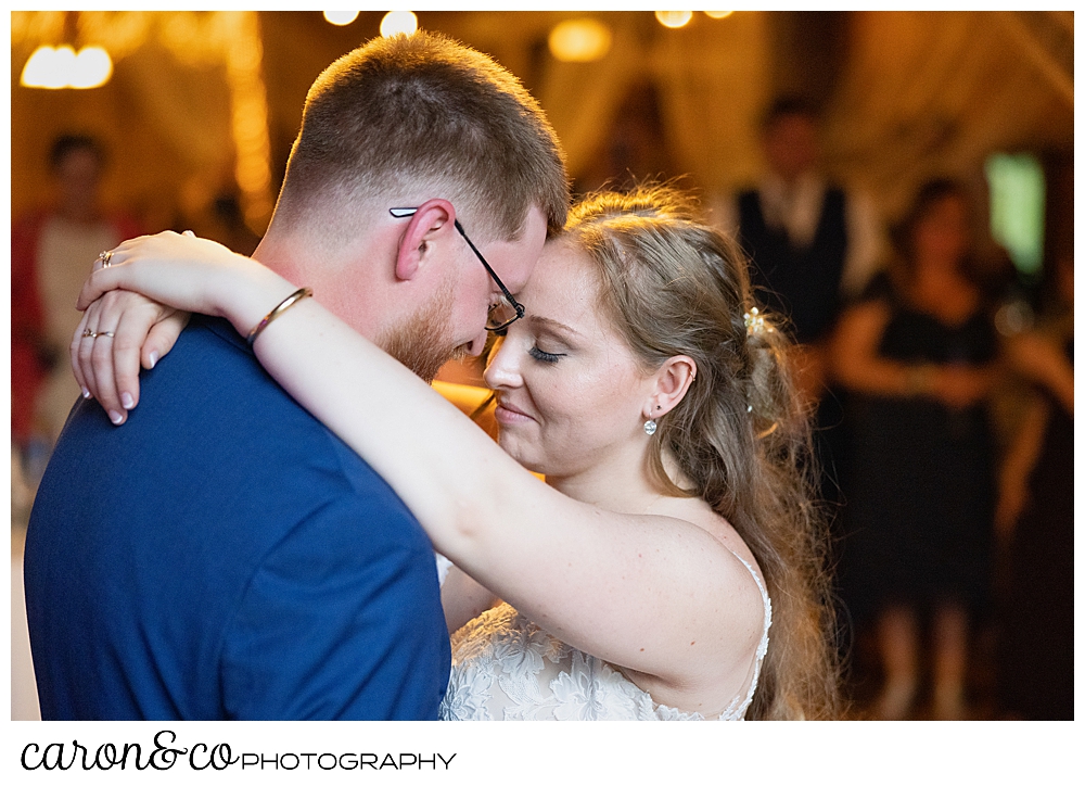 bride and groom dancing their first dance, their foreheads together