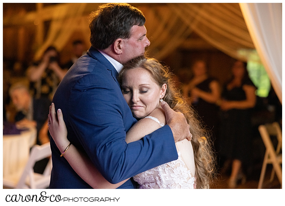 bride and her father hugging during the father daughter dance at their highland lake Maine wedding reception