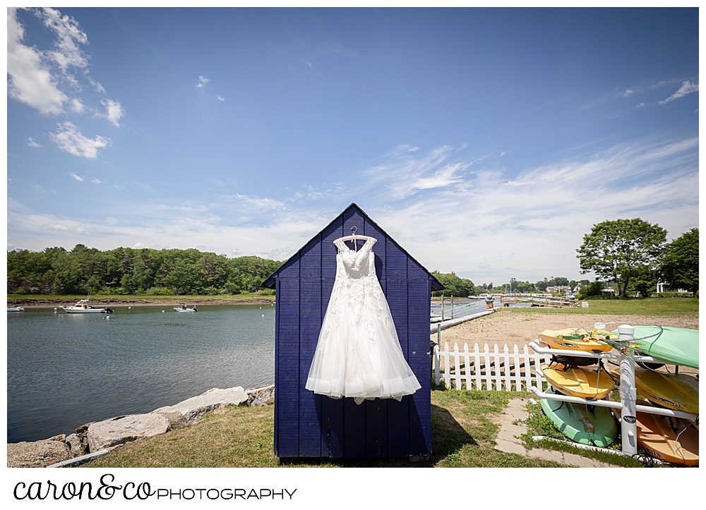 a wedding dress hangs from a purple shed on the Kennebunk River, Kennebunkport, Maine