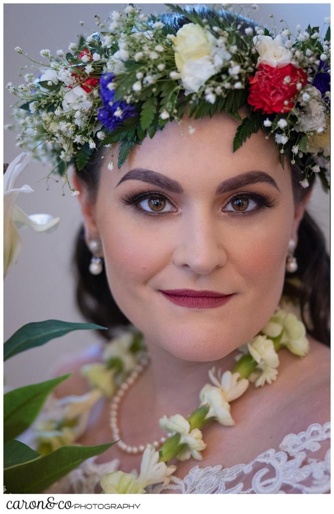 beautiful bridal portrait of a dark haired bride, wearing a flowered headpiece, and a white lei