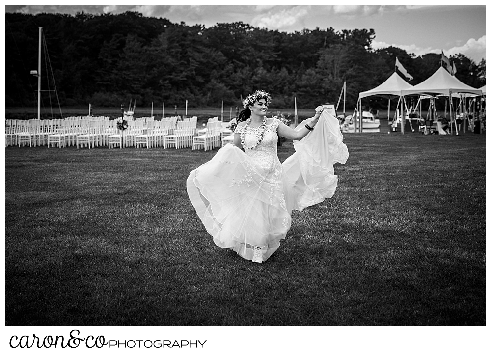 black and white photo of a bride walking around her outdoor ceremony venue at a Nonantum Resort tented wedding, Kennebunkport, Maine