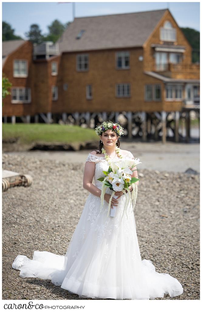 a full length photo of a bride waiting to do a Nonantum Resort tented wedding first look, there is a brown house in the background