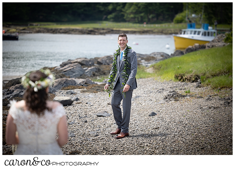 a groom wearing a gray suit, turns to see his bride during a Nonantum Resort tented wedding first look