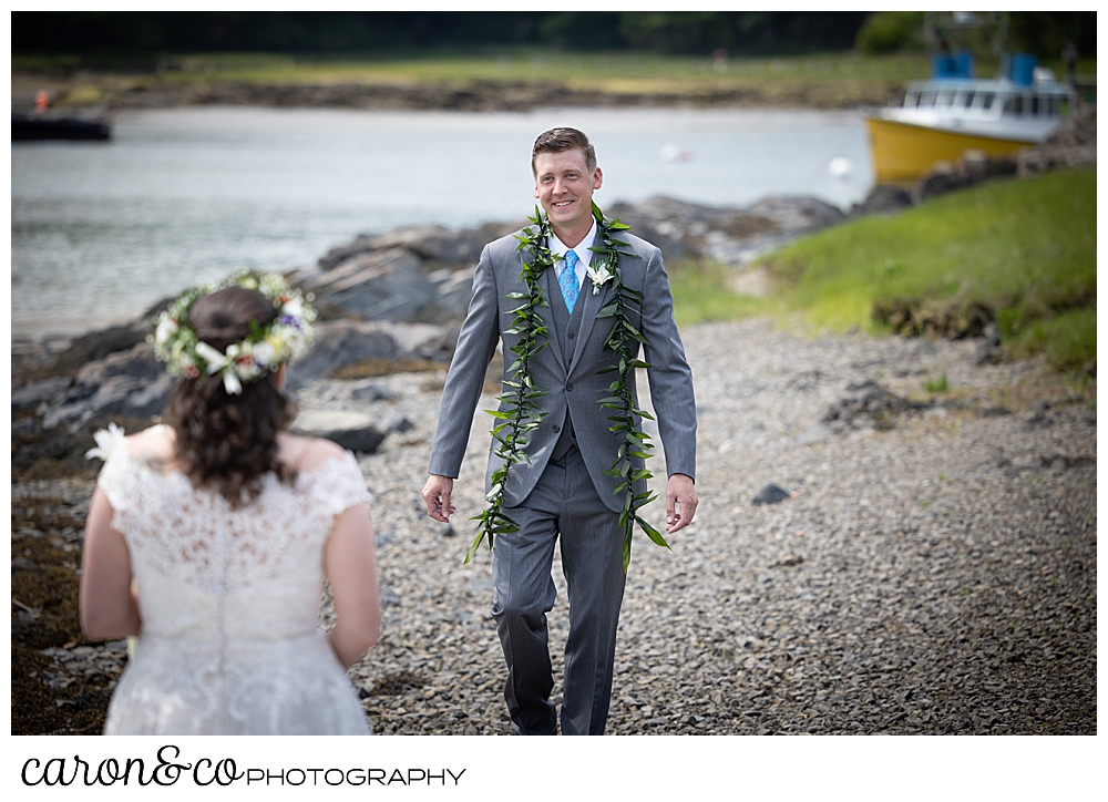 a groom wearing a gray suit, walks towards his bride, during a Nonantum Resort tented wedding first look