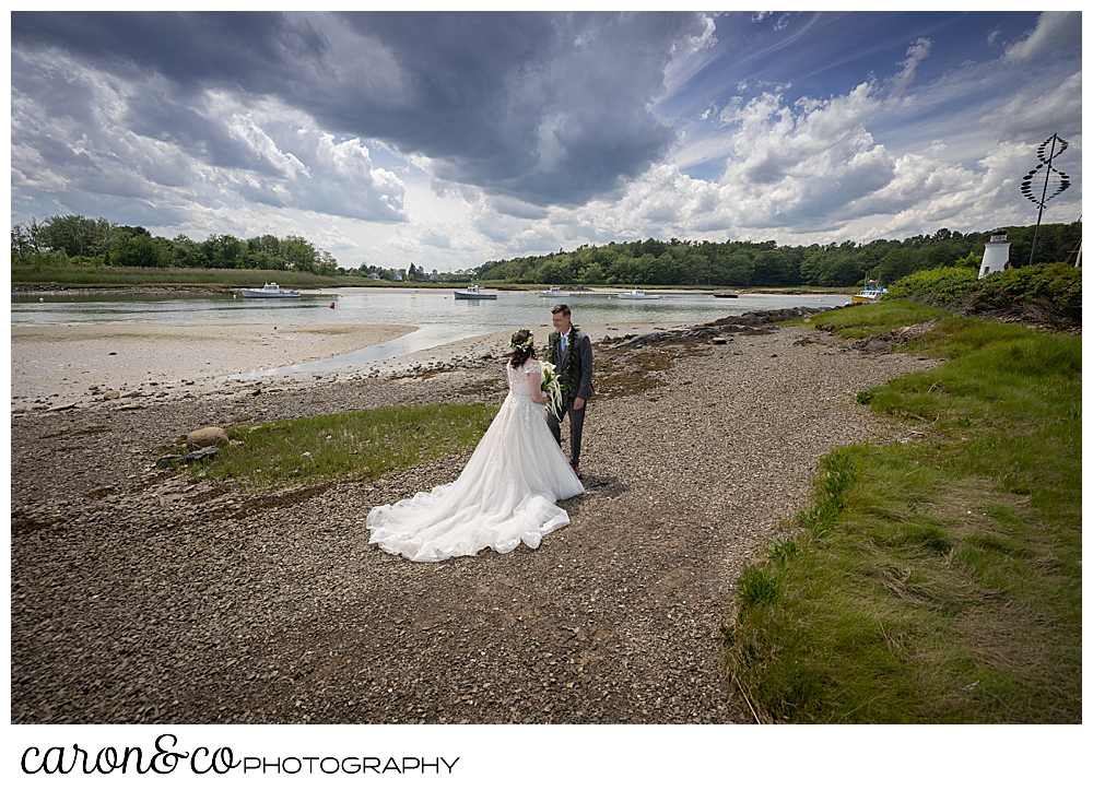 a bride and groom on the banks of the Kennebunk River, during a wedding day first look, at a Nonantum Resort tented wedding