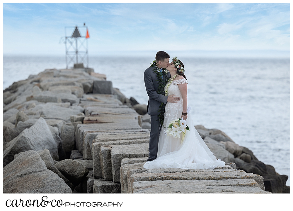 a bride and groom kiss on the top of the Kennebunkport Breakwater, Kennebunkport, Maine