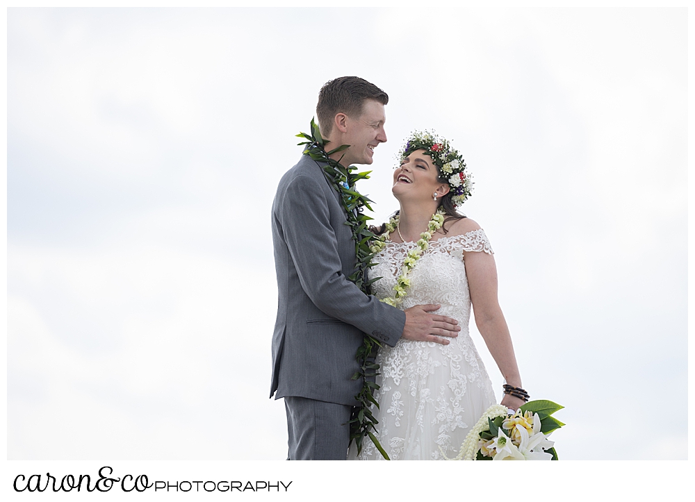 a bride and groom stand together, smiling and talking