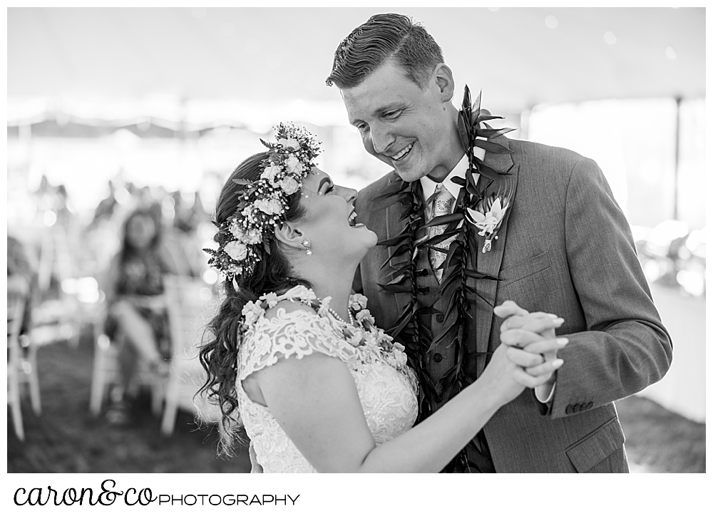 black and white photo of a bride and groom laughing together as they enjoy their first dance at their Nonantum Resort tented wedding