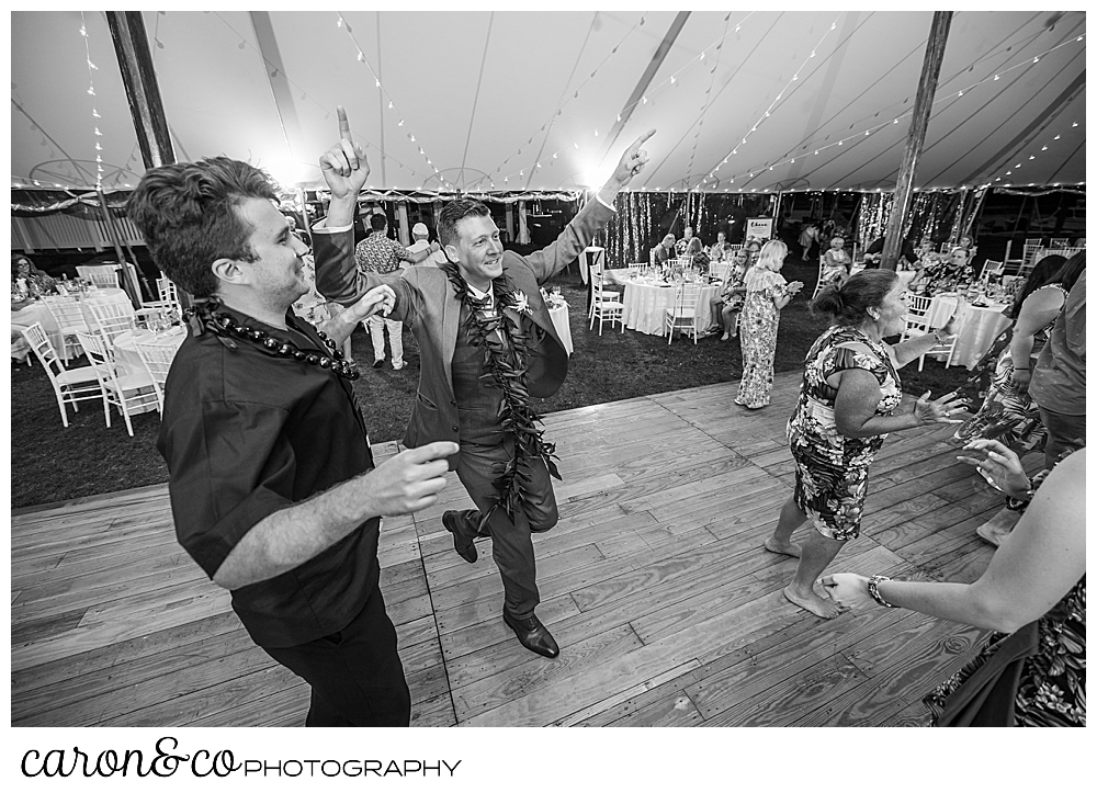 black and white photo of guests dancing , two men are in the foreground, at a Nonantum Resort tented wedding