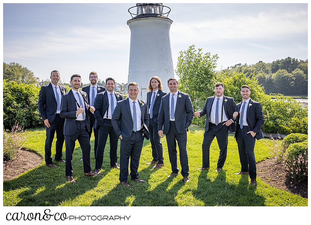 a groom and his groomsmen stand together in front of the lighthouse at the Nonantum Resort, Kennebunkport, Maine