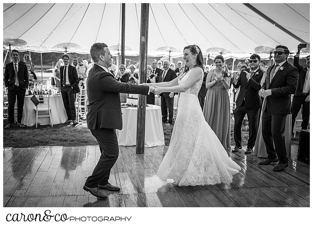 black and white photo of a bride and groom dancing their first dance under the Sperry Tents Seacoast tent, and their Nonantum Resort wedding celebration