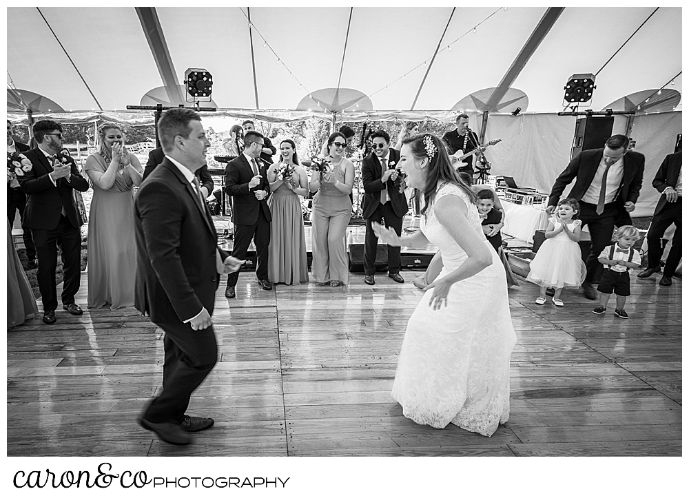 black and white photo of a bride and groom dancing at their Nonantum Resort wedding celebration, their wedding party is surrounding the dance floor