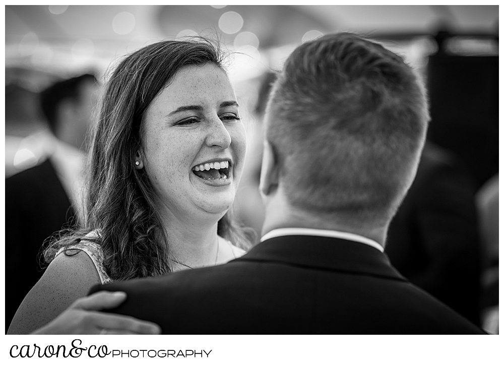 black and white photo of a bride smiling at her groom as they dance their first dance at their Nonantum Resort wedding celebration