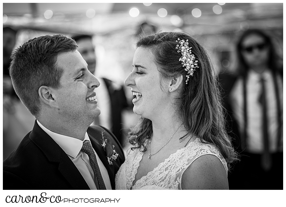 black and white photo of a bride and groom smiling at one another as they dance their first dance at their Nonantum Resort wedding celebration