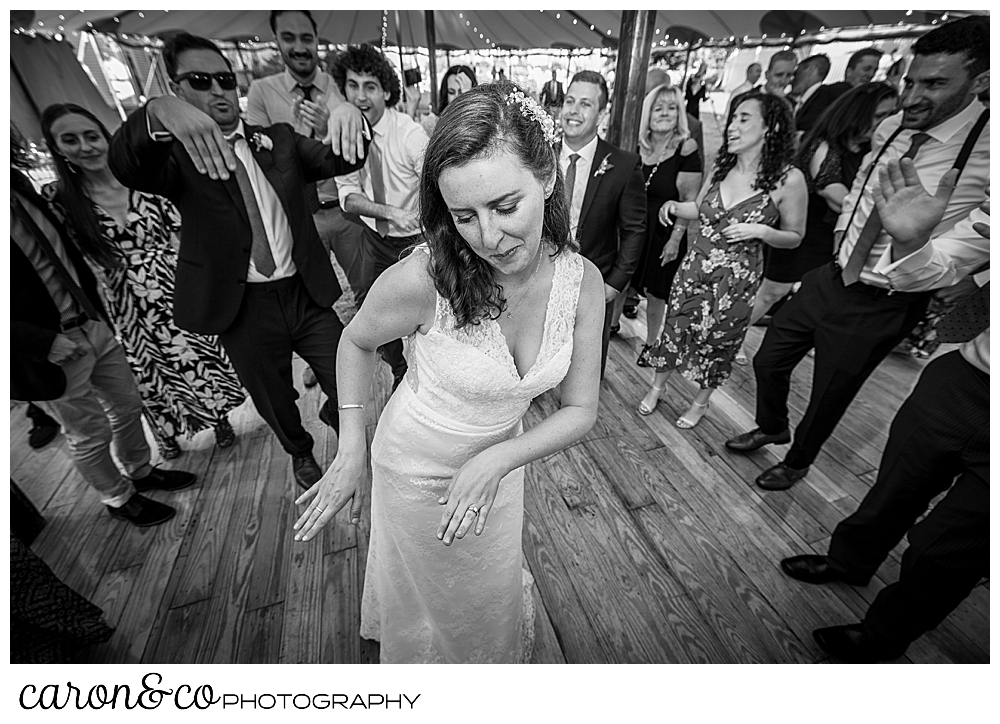 black and white photo of a bride dancing at her Nonantum Resort wedding celebration, she's surrounded by wedding guests