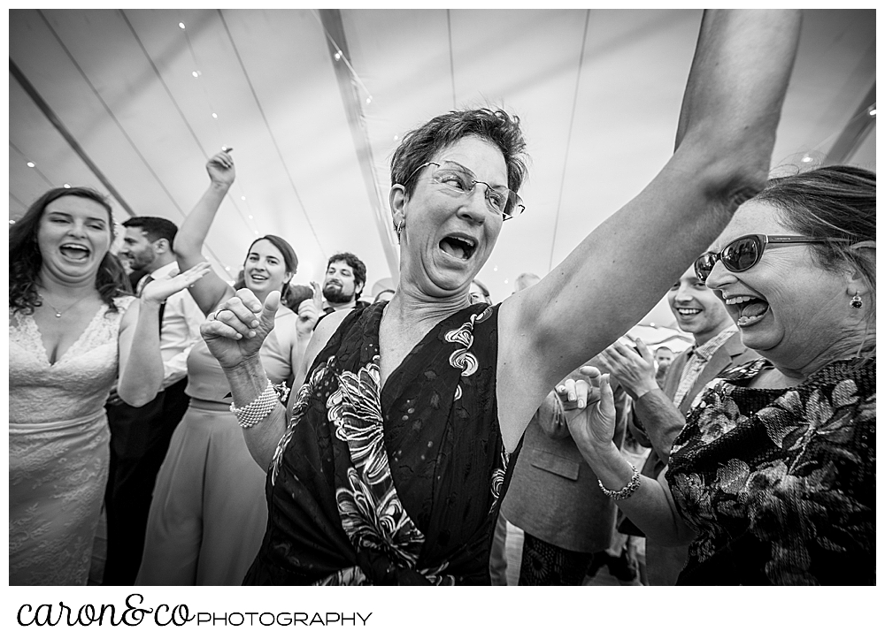 black and white photo of a woman dancing in the foreground, there are people dancing around her