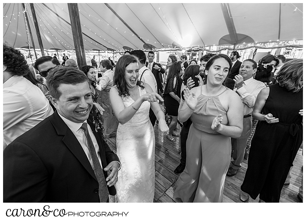 black and white photo of a bride dancing with her friends