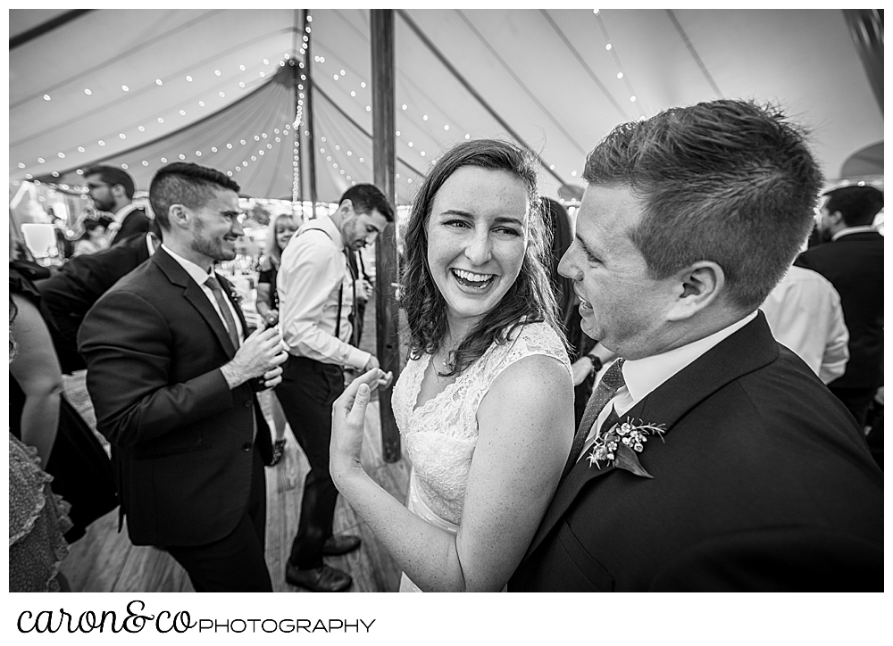 black and white photo of a bride turning to smile at her groom, while they're dancing during a Nonantum Resort wedding celebration