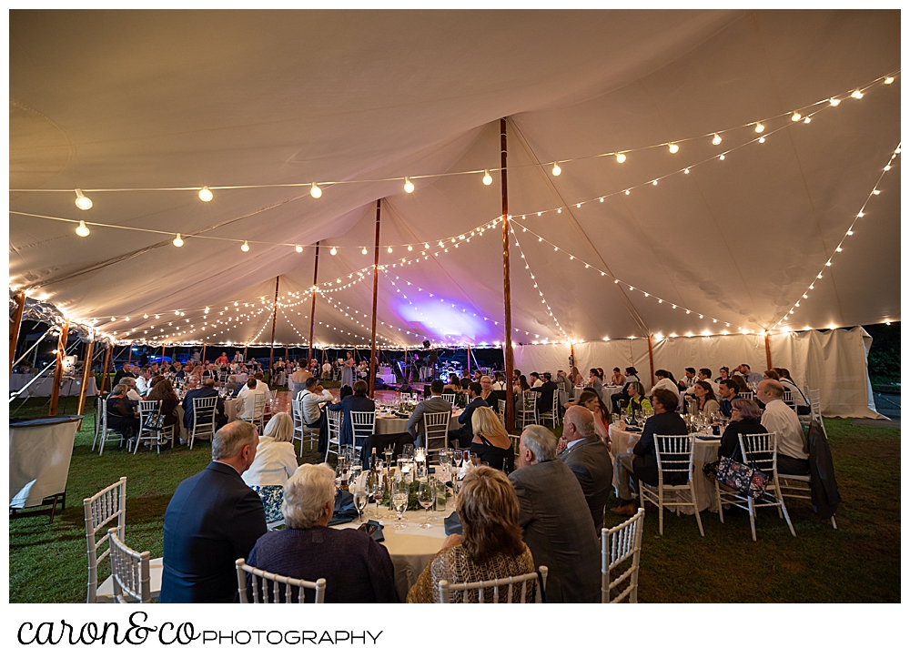 guests are seated at round tables under a Sperry Tent Seacoast tent, at a Nonantum Resort wedding celebration