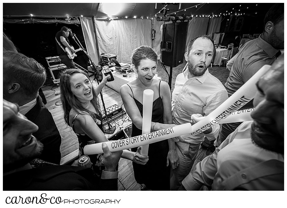 black and white photo of wedding guests with light sabers on the dance floor