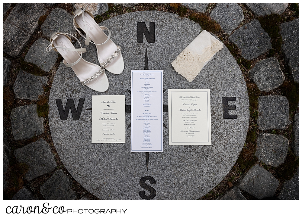 bridal day details, shoes, handkerchief, and paper suite arranged in a compass rose inlay of stone in a garden