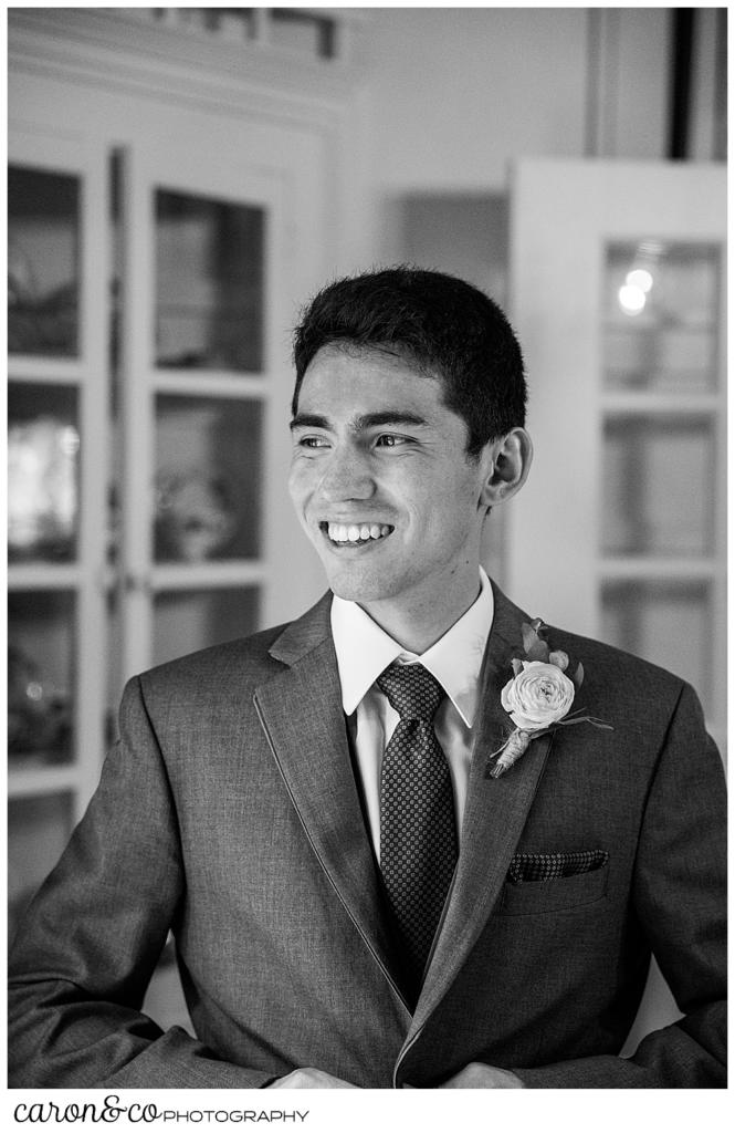 black and white photo of a groom buttoning his jacket