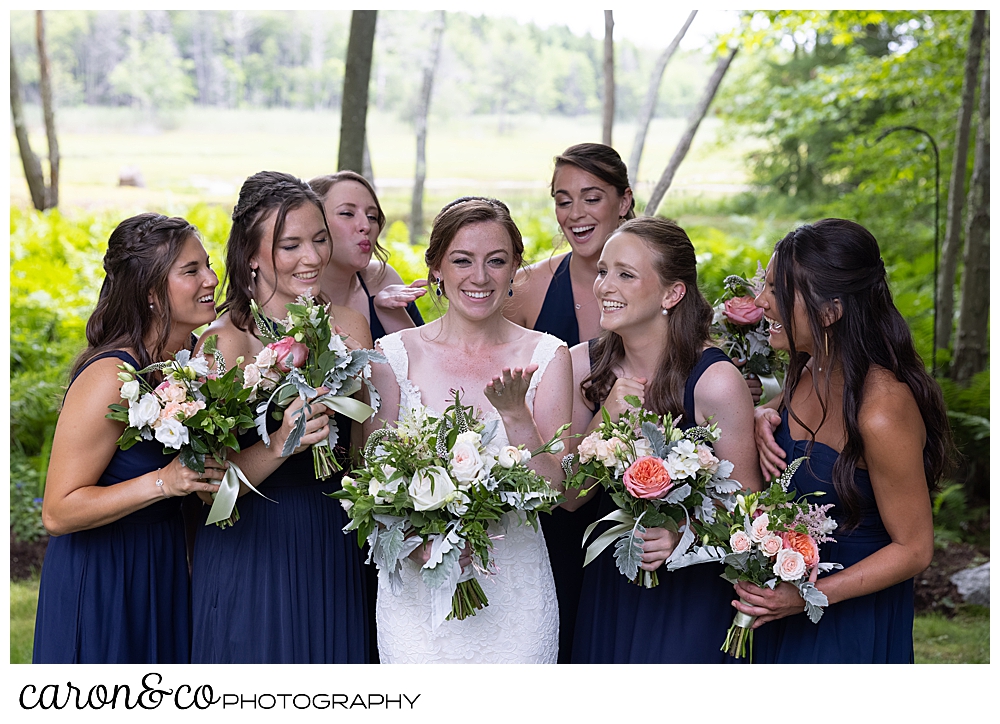 a smiling bride in white, surrounded by her bridesmaids in blue
