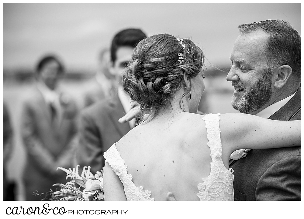 A black and white photo of a bride and her father as they part at the end of the aisle at a St. Ann's by-the-sea Episcopal Church outdoor ceremony