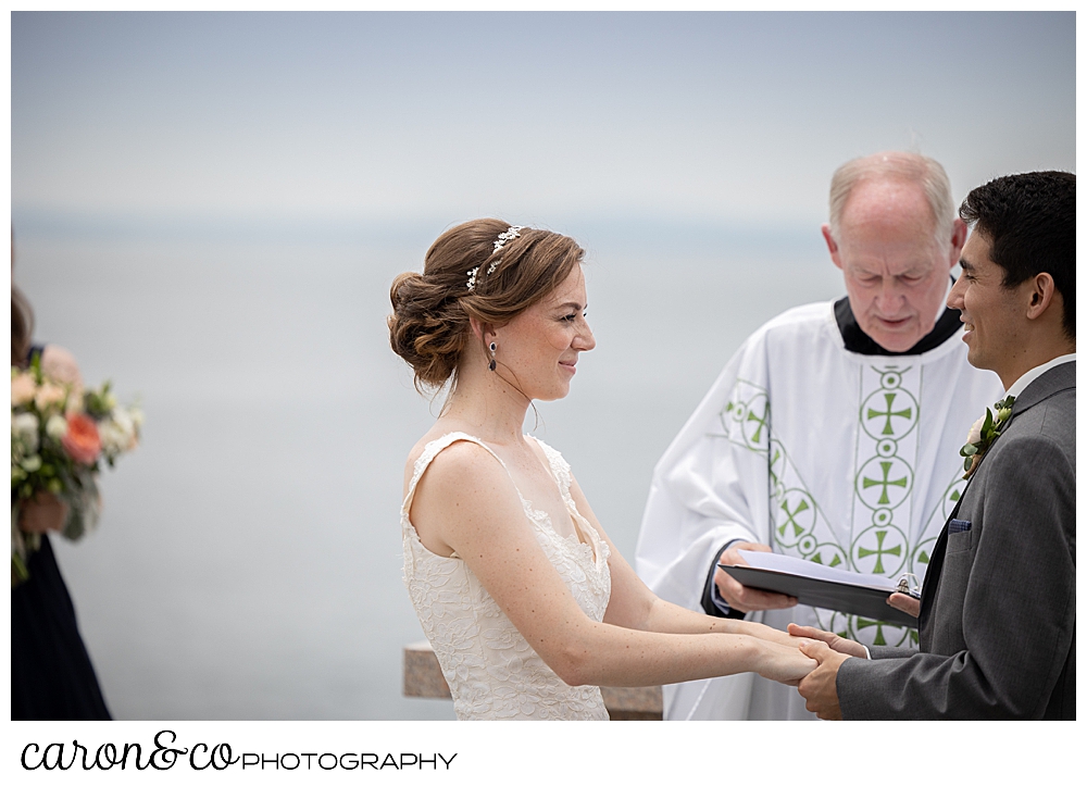 a bride looks at her groom during an outdoor wedding ceremony