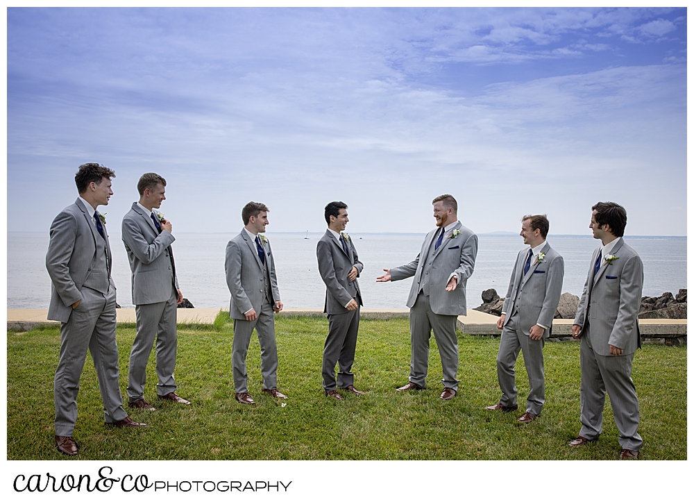 a groom and six groomsmen stand together, laughing