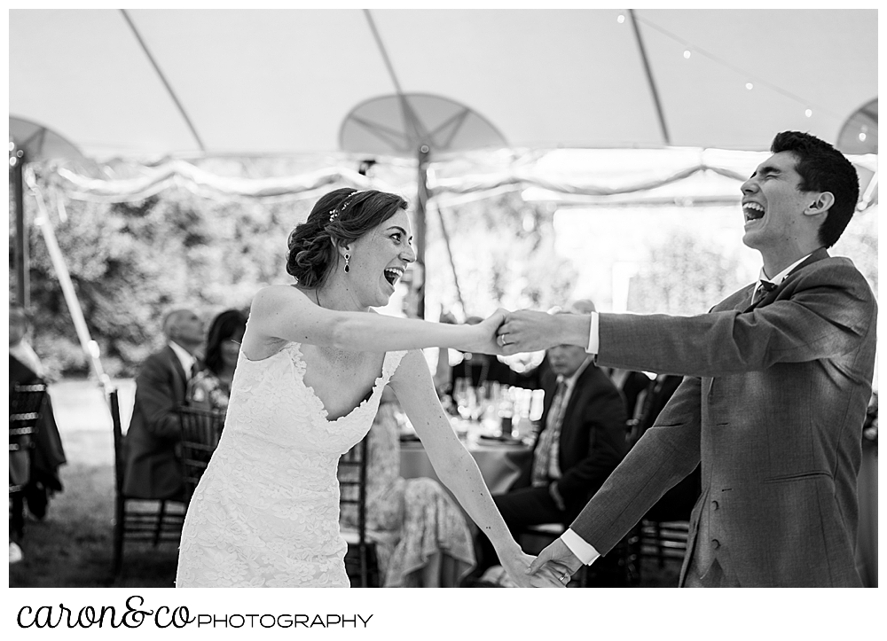 black and white photo of a bride and groom dancing and laughing during their first dance at a Kennebunk Maine wedding reception